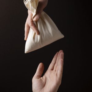 hand giving bag with grains